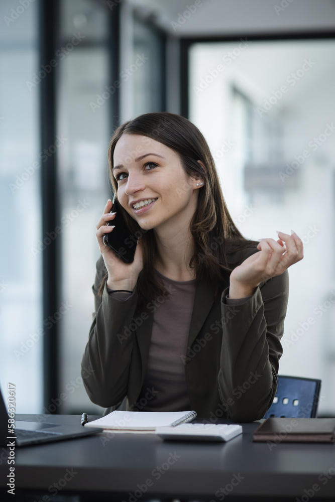 Happy excited young successful business woman and working online at the table in office, 