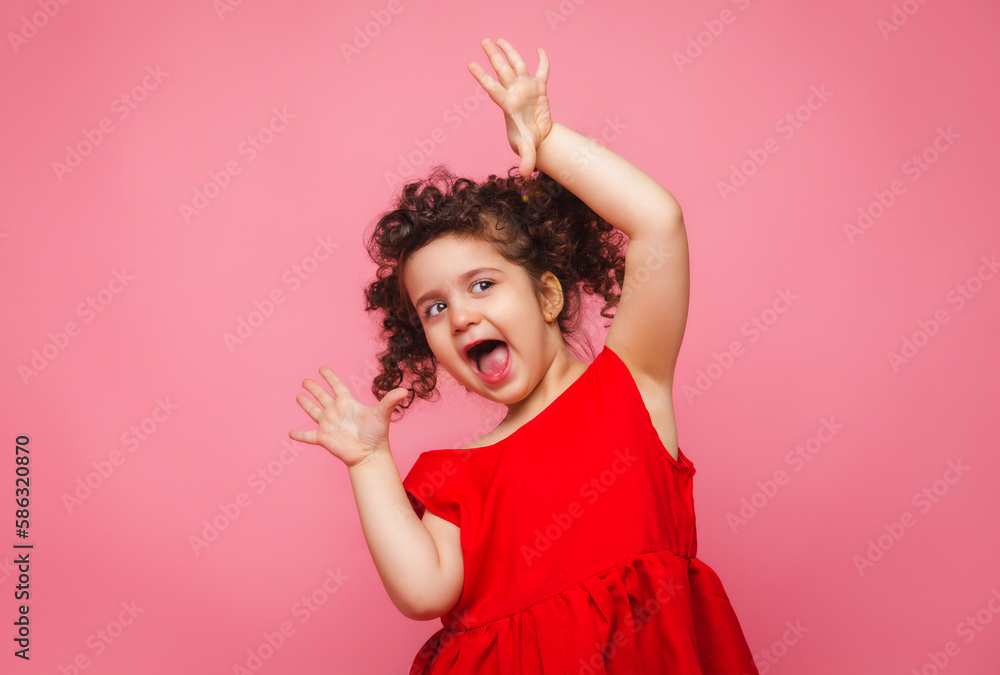 emotional portrait of a little girl in a red dress on a pink background. emotional portrait of a little girl in a red dress on a pink background.