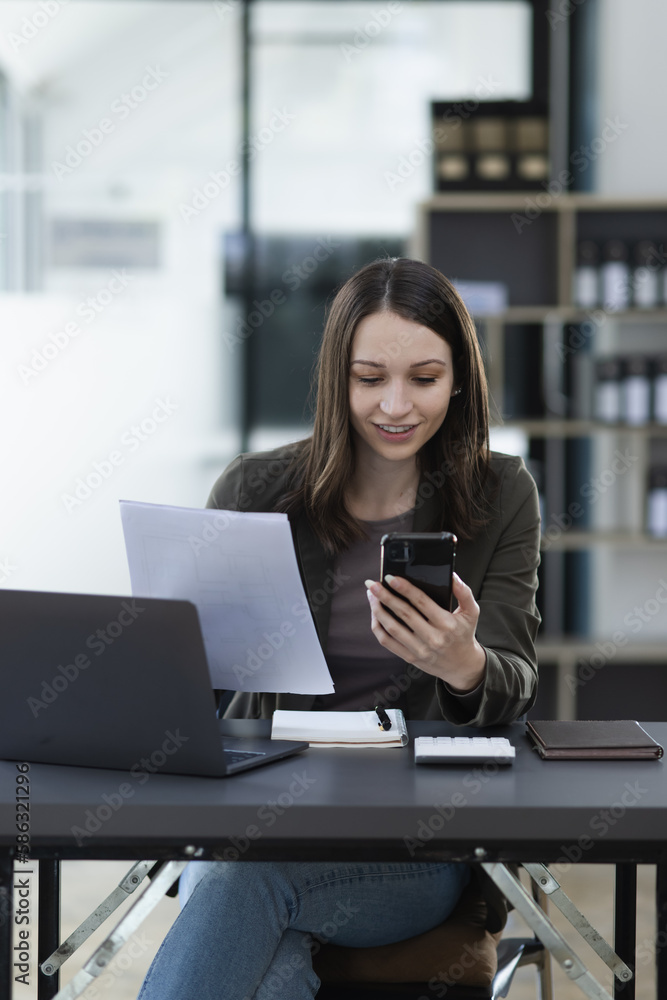 Happy excited young successful business woman and working online at the table in office, Happy excited young successful business woman and working online at the table in office,