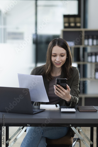Happy excited young successful business woman and working online at the table in office, 