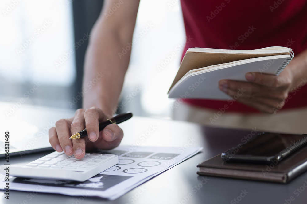 businessmen use calculator and smartphone with financial at desk in office. businessmen use calculator and smartphone with financial at desk in office.
