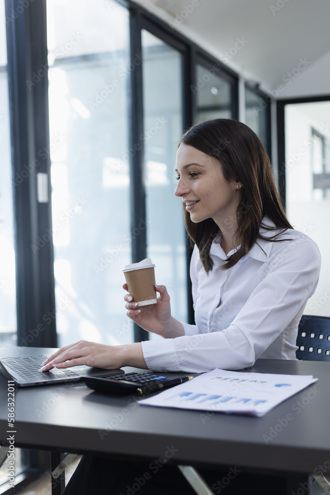 Happy excited young successful business woman and working online at the table in office, Happy excited young successful business woman and working online at the table in office,