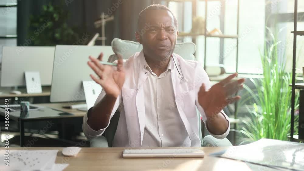 Camera view of confused african american doctor therapist looking at camera and decline disagree with the patient's treatment methods against folk medicine by online distance video call conference Camera view of confused african american doctor therapist looking at camera and decline disagree with the patient's treatment methods against folk medicine by online distance video call conference