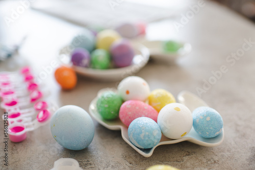 Colorful Easter eggs in rabbit shape plate on kitchen table closeup. Holiday celebration.