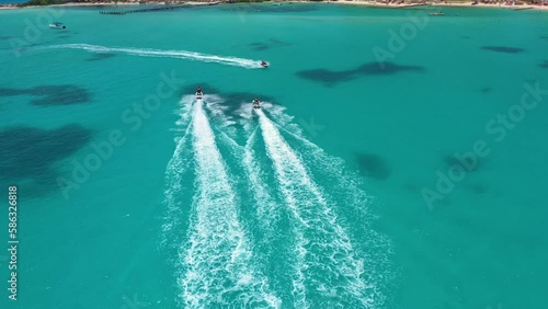 Aerial view of riding people on jet ski (personal watercraft). Caribbean beach on Cancun hotel zone, Mexico.