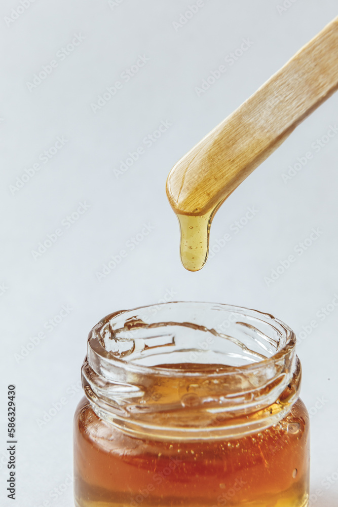 Sugar paste for depilation shugaring in a glass jar with wooden spatula. Natural Honey Sugar paste for depilation shugaring in a glass jar with wooden spatula. Natural Honey