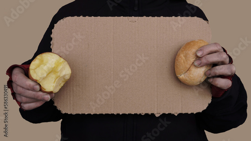 a woman in red gloves holds a sign for an inscription made of cardboard. on the sides of the sign in his hands is a bitten apple and a piece of bread  photo