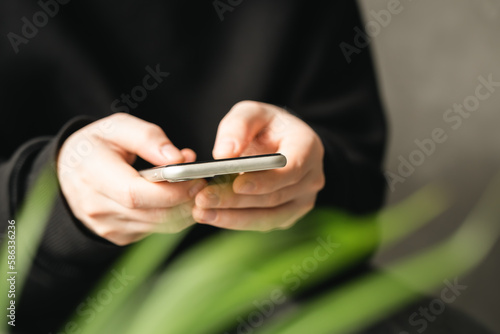 Smartphone in the hands of a man close-up on a blurred background, the concept of using technology, shopping online, communicating remotely. photo