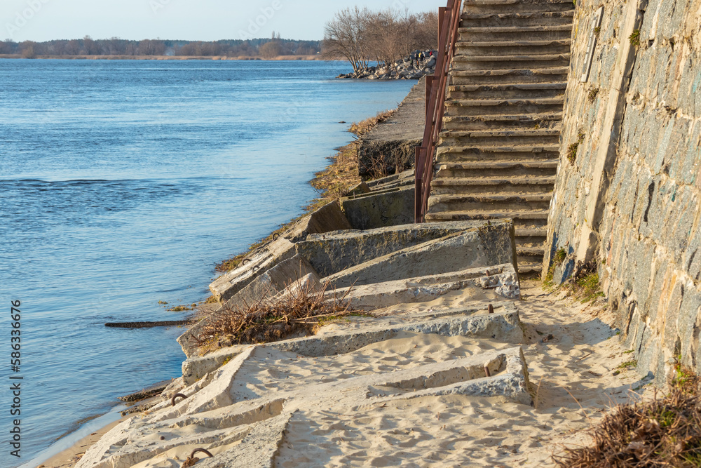 Destroyed river embankment and old stairs, collapsed concrete blocks and slabs Destroyed river embankment and old stairs, collapsed concrete blocks and slabs