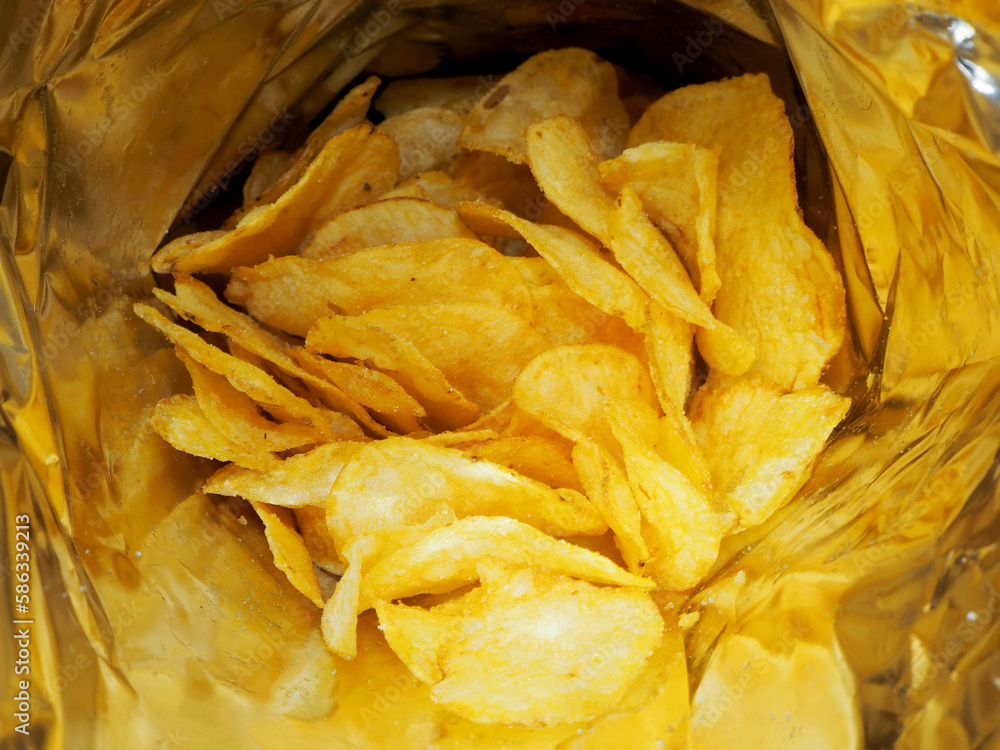 inside is an open pack of potato chips. fatty junk food dot snack Stock Photo Adobe Stock