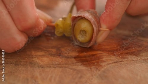 Woman making Gilda, typical Spanish tapas, Traditional Basque Country pincho with chili pepper photo