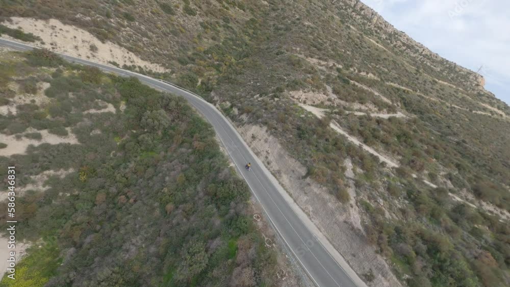 Fpv drone chasing motorbike driven by redhead woman on road Fpv drone chasing motorbike driven by redhead woman on road