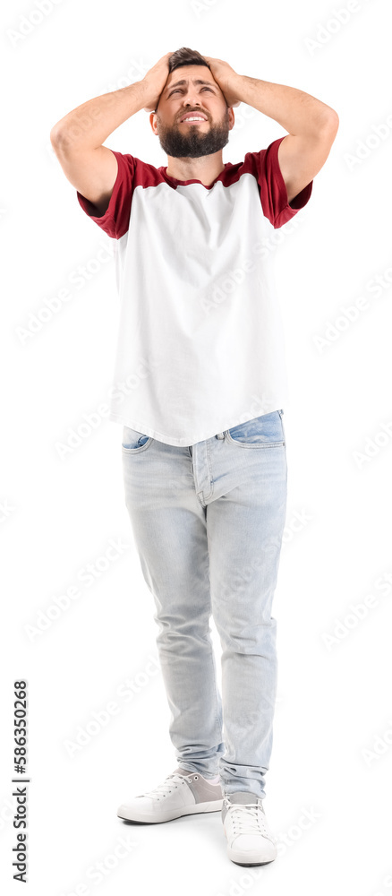 Irritated young man suffering from loud noise on white background Irritated young man suffering from loud noise on white background