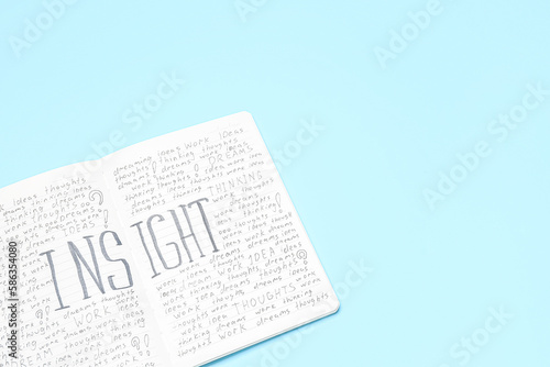 Notebook with word INSIGHT on blue background