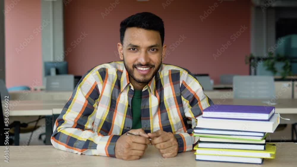 Portrait of young indian student in lecture room. Indian or Pakistani student at modern university Portrait of young indian student in lecture room. Indian or Pakistani student at modern university
