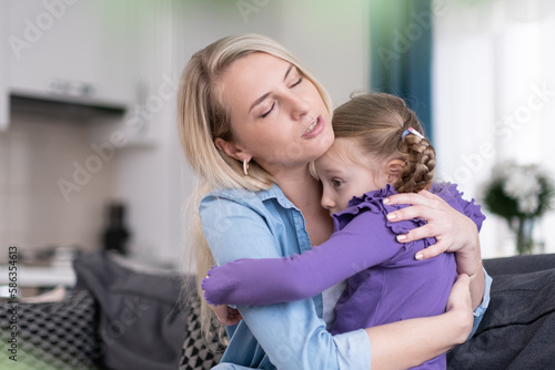 mother comforting and hugging upset scared girl at home, Parent protection and support
