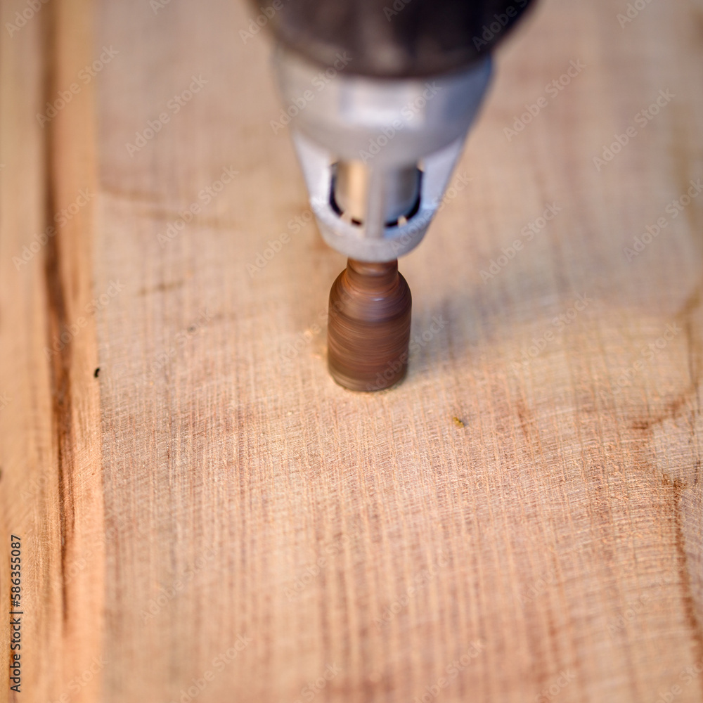 A screwdriver, tighten screw in wooden board A screwdriver, tighten screw in wooden board