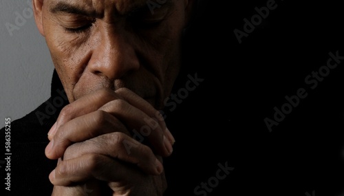 man praying to god with hands together Caribbean man praying with black background stock photos stock photo	