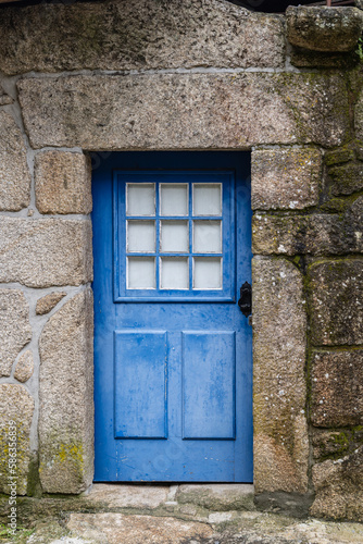 A bright blue door in a stone wall.