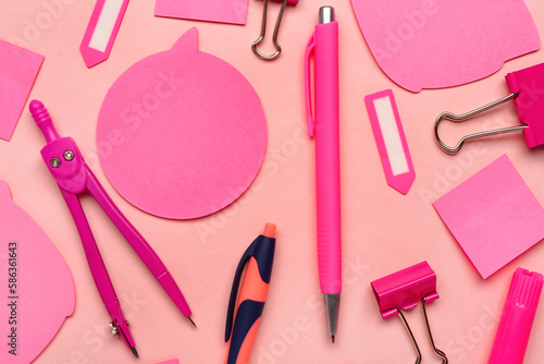 Composition with pens, sticky notes and paperclips on pink background