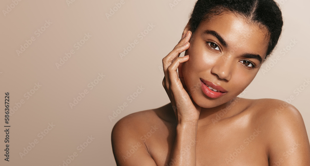 Cosmetology and spa. Young black woman with soft healthy skin, touches her face after cleanser, cosmetic product, skincare cosmetics after effect, standing over brown background Cosmetology and spa. Young black woman with soft healthy skin, touches her face after cleanser, cosmetic product, skincare cosmetics after effect, standing over brown background
