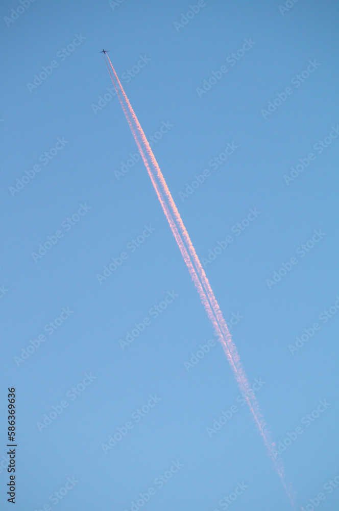 Silhouette of a passenger plane in the sky with a contrail. The plane takes off at sunset. Silhouette of a passenger plane in the sky with a contrail. The plane takes off at sunset.
