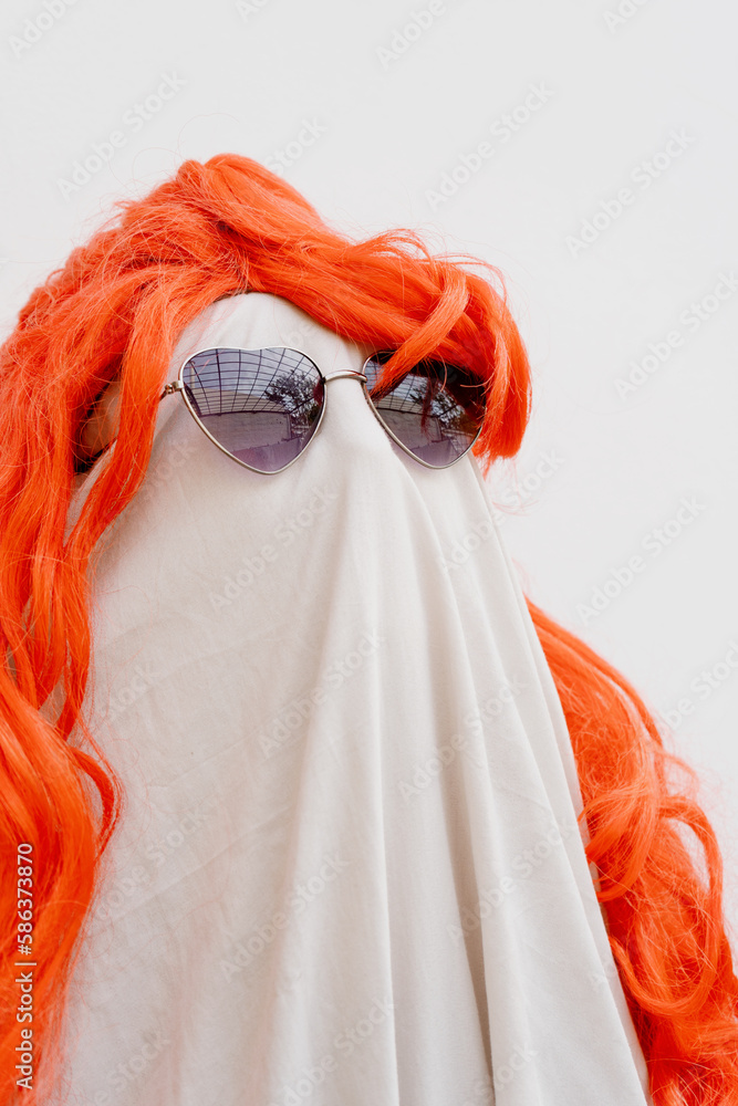 Un espectro colorido: Disfraz de fantasma con sábana blanca, lentes y  peluca roja foto de Stock | Adobe Stock