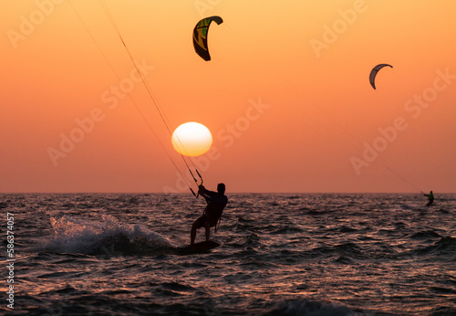 People ride a Kiteboarding during the sunset. Mediterranean sea, Israel