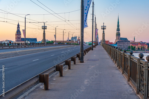 Sunset at the old town of riga including saint peters church viewed over daugava river, Latvia. photo