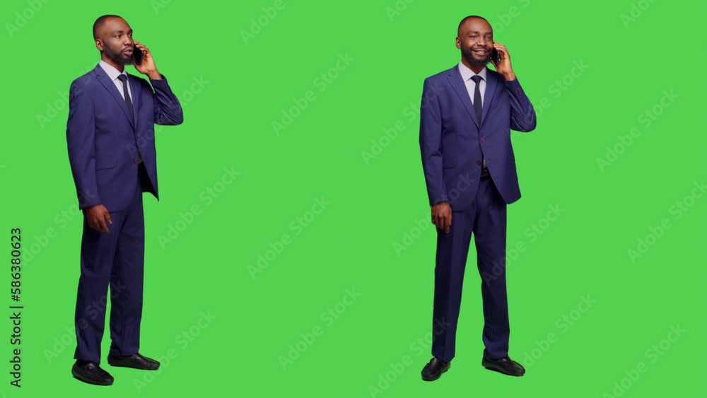 Young businessman in suit talking on phone call, standing over full body greenscreen. Male office employee having remote conversation using smartphone line in studio, enjoying telephone chat. Young businessman in suit talking on phone call, standing over full body greenscreen. Male office employee having remote conversation using smartphone line in studio, enjoying telephone chat.