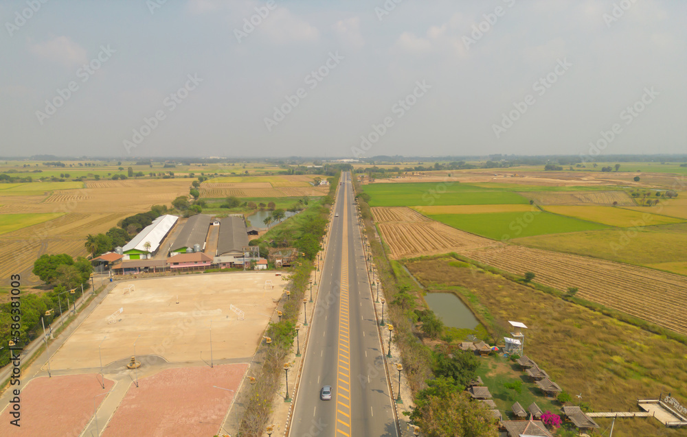 Aerial top view of road street with paddy rice terraces, green agriculture fields in countryside, mountain hills valley, Thailand. Nature landscape. Crops harvest.