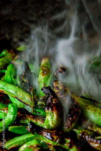 shishito peppers smoking over the charcal photo