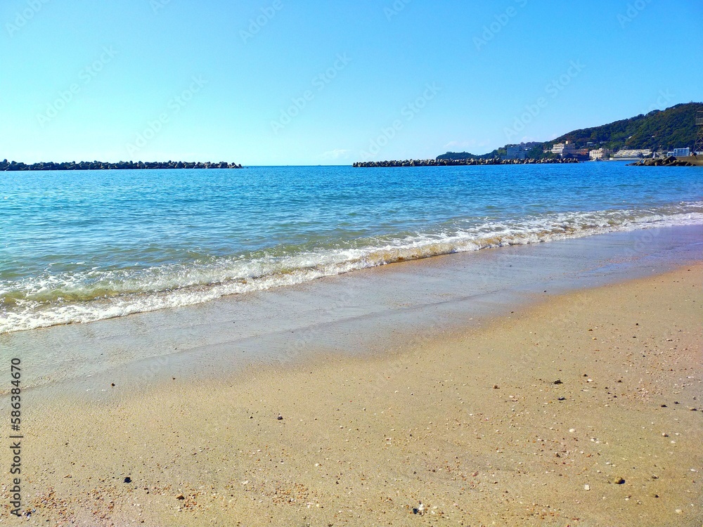 日本の和歌山県の観光地、快水浴百選海の部特選にも選ばれた片男波海水浴場の砂浜の波打ち際の夏の風景（コピースペースあり）