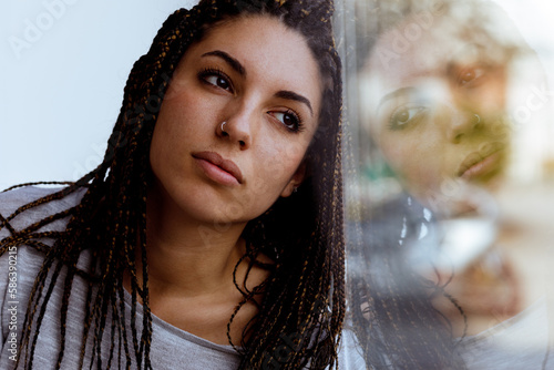 Foto Serious girl, box braids, gazing out, dreamy or planning, in gra