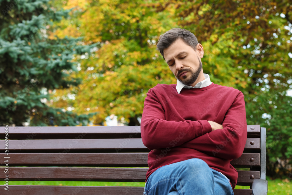 Tired man sleeping on bench in beautiful green park. Space for text Tired man sleeping on bench in beautiful green park. Space for text