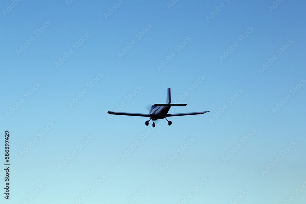 Modern ultralight airplane flying in blue sky