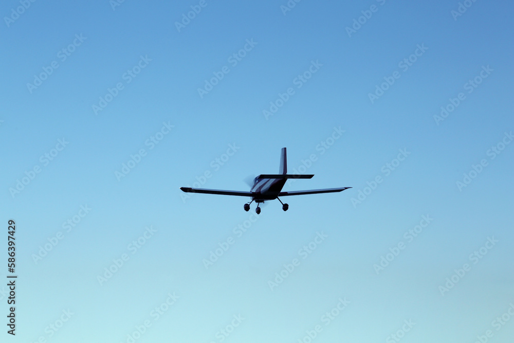 Modern ultralight airplane flying in blue sky Modern ultralight airplane flying in blue sky