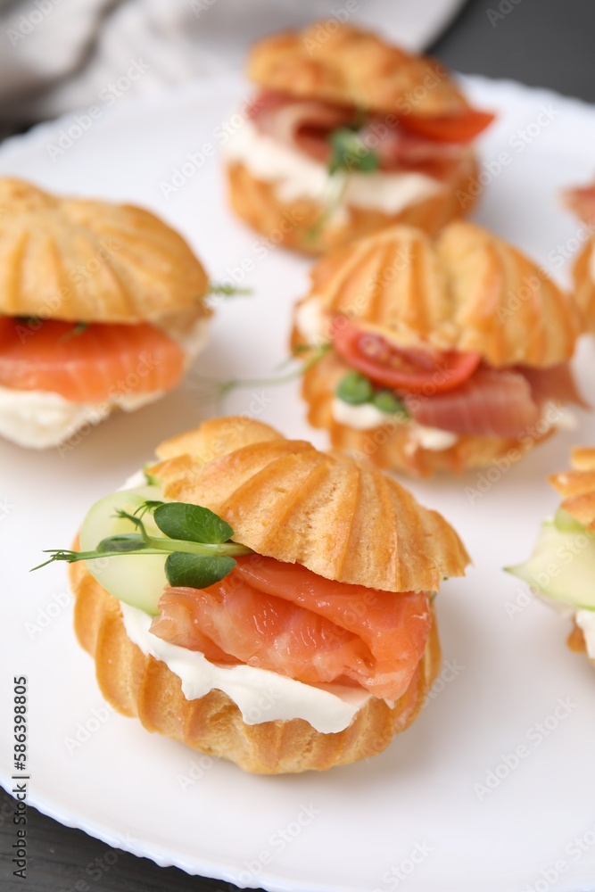 Delicious profiteroles with tasty filling on table, closeup Delicious profiteroles with tasty filling on table, closeup