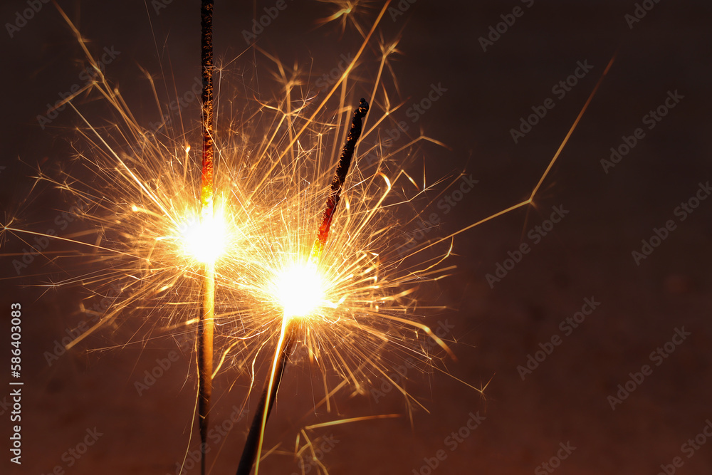 Close up of Sparkler on beach. Burning sticks of Bengal fire, Sparks of bright bengal lights burning on the beach.