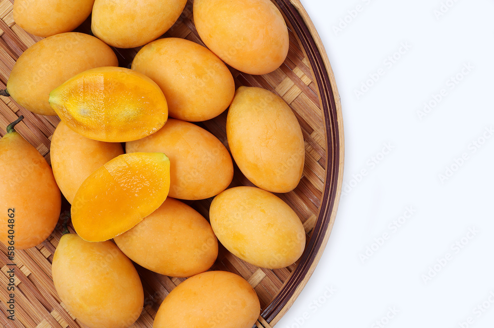 Fresh Marian Plum, (Bouea macrophylla Griffith), Ripe plum mango on bamboo colander on a white background. Fresh Marian Plum, (Bouea macrophylla Griffith), Ripe plum mango on bamboo colander on a white background.