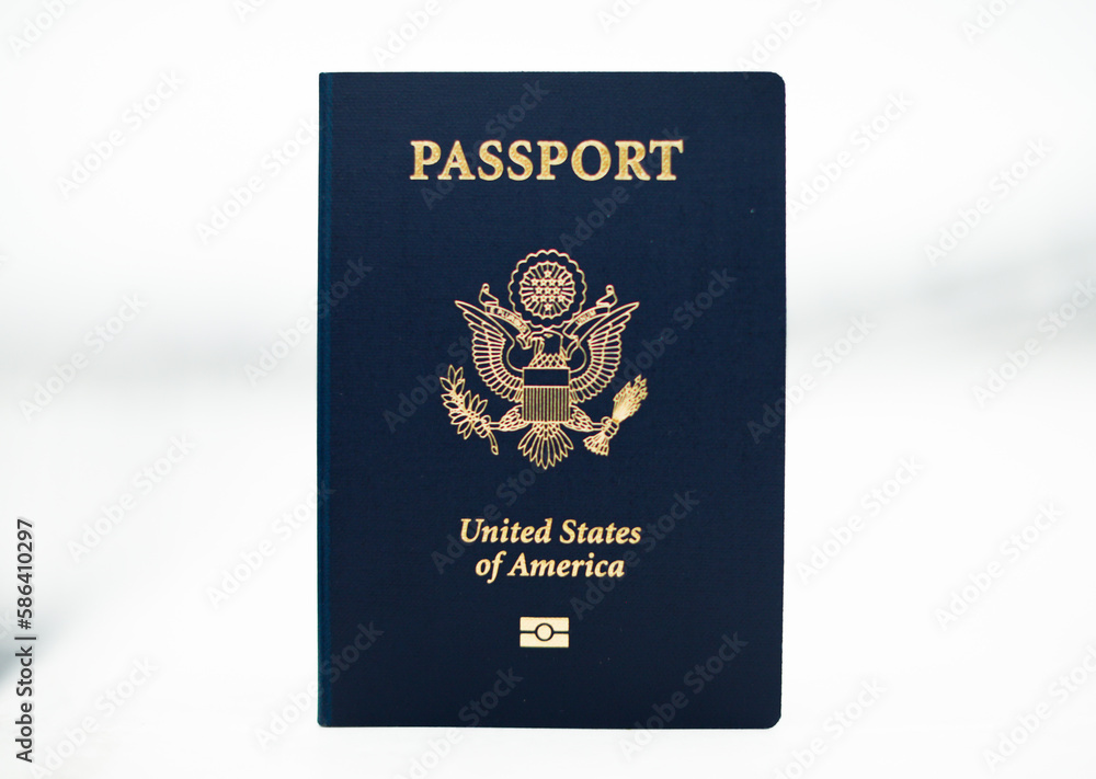 Close-up of a US passport with immigration, visa, citizenship, and travel paperwork on a wooden table Close-up of a US passport with immigration, visa, citizenship, and travel paperwork on a wooden table