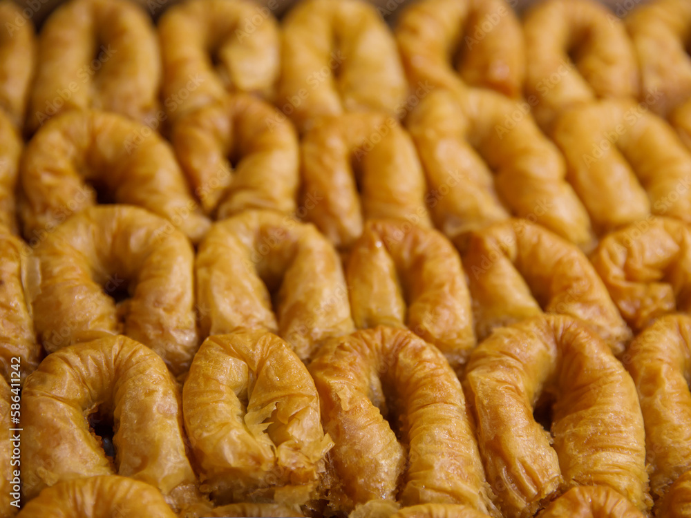 baklava rolls nest, oriental dessert made of phyllo, nuts, butter and syrup served on tray. Traditional turkish, arabic, jewish sweet. Full frame background, top view