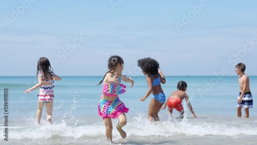 Group of Diversity little child boy and girl friends running and playing sea water at tropical beach together on summer vacation. Happy children kids enjoy and fun outdoor lifestyle on beach holiday.