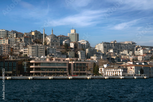View of the embankment-boulevard of the Galataport shopping and entertainment center in the Karakey area and the Cihangir Mosque on a sunny day, Istanbul, Turkey