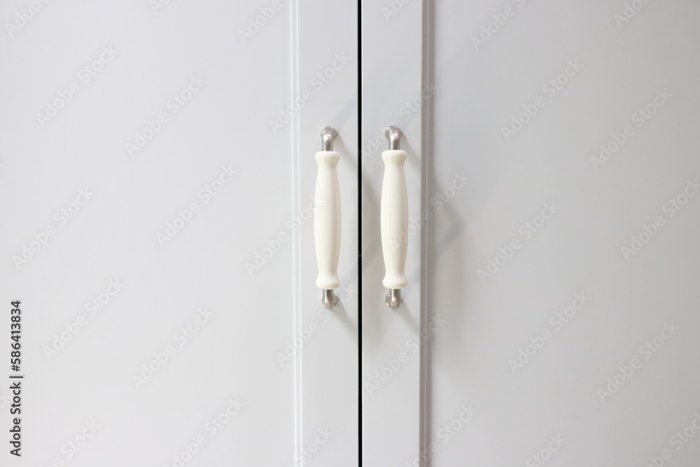 Handle to open and close the white wardrobe door. Handle to open and close the white wardrobe door.