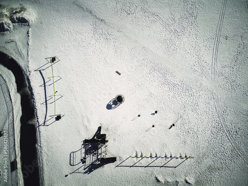 Photography Aerial overhead drone view of school playground equipment covered in snow