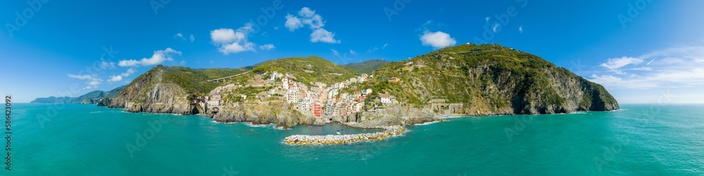 Aerial panorama top view of Riomaggiore colorful fishing village one of the five Cinque Terre Villages in national park, sequence of hill cities along the coastline of Ligurian Sea in Italy. 