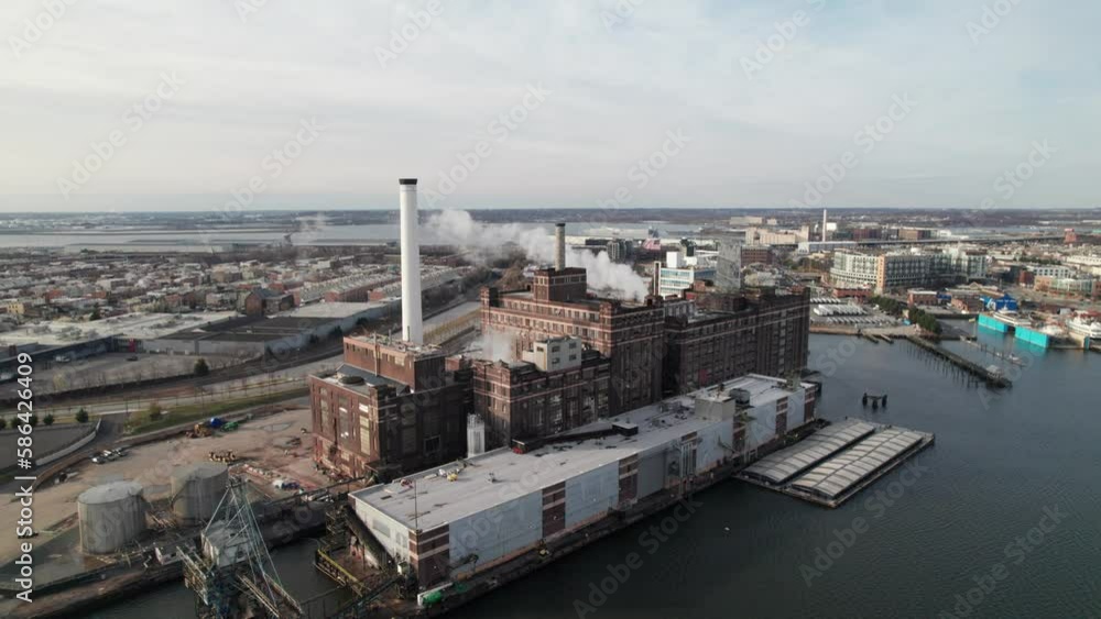 All American manufacturing. Large industrial factory complex on the East cost with smokestacks, shipping cranes. All American manufacturing. Large industrial factory complex on the East cost with smokestacks, shipping cranes.
