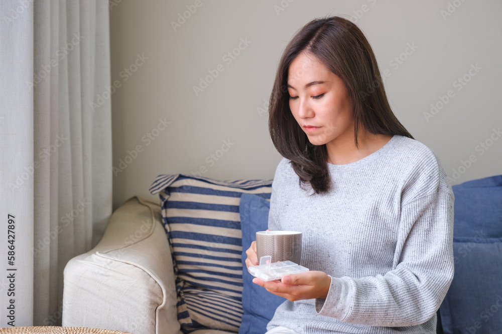 Portrait image of a young woman holding and taking pills Portrait image of a young woman holding and taking pills