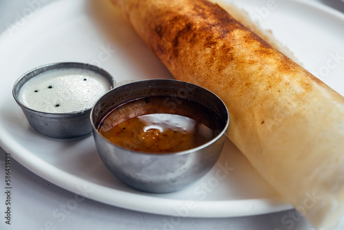 Dosa, dhosa, masala, plain, maisuri (Ghee Roast) made of corn flour with Chutney and Sambar. Indian main breakfast item which is beautifully arranged in a white plate close up photo